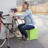 Woman using Handy Home Seat in green to clean a bicycle