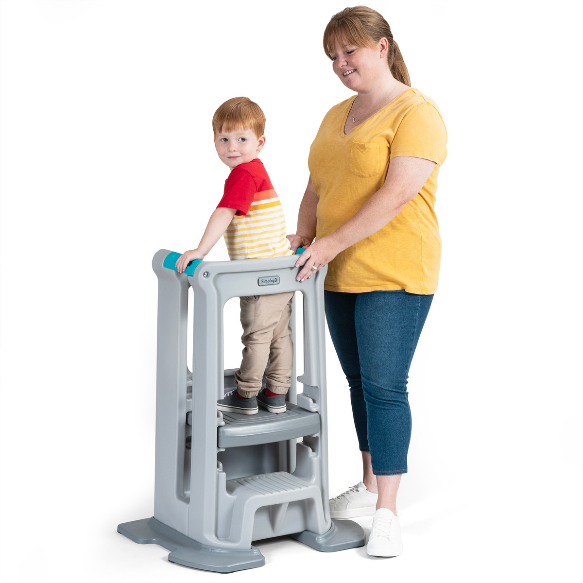 Toddler enclosed in center of Toddler Tower platform standing with  parent supervising at side.