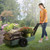 Woman pulling Simplay3 American Home Flat Bed Cart in garden with mulch and flowers